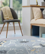 Круглый детский ковер Tarkett Sunny Kids 13KWK с динозаврами в интерьере детской, ракурс у кресла