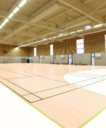 Пример бесшовной укладки амортизирующего линолеума Tarkett Omnisports Maple Light Maple в просторном игровом зале