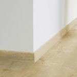 Плинтус Tarkett Alpine Oak Warm Natural в тон напольного покрытия в интерьере.