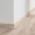 Плинтус Tarkett Antik Oak Grey в тон напольного покрытия в интерьере.