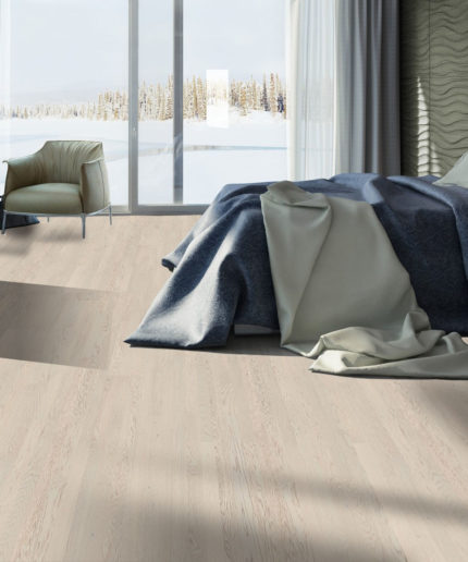 Паркетная доска Tarkett Salsa Premium Oak Pearly наполняет светом спальню с панорамным остеклением, синим покрывалом и креслом у окна.