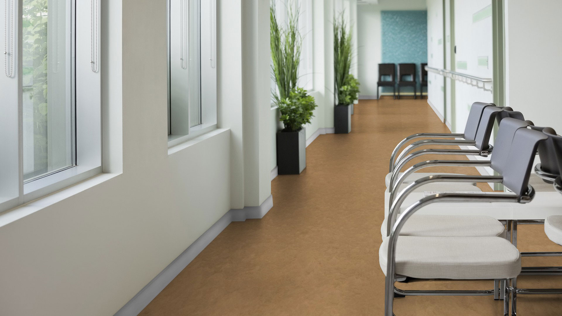 Линолеум Tarkett Veneto xf² Linen 400 бежево-серого цвета в интерьере светлого больничного коридора со стульями для ожидания.
