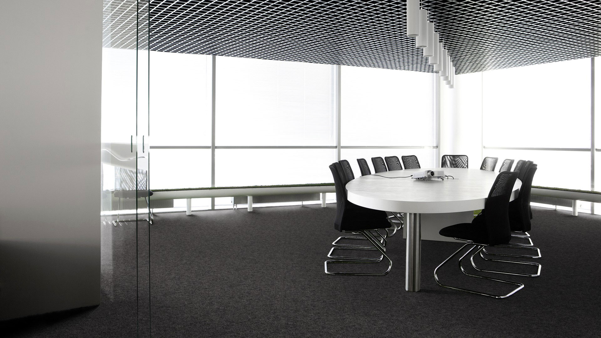 Ковровая плитка Desso Metallic Shades 9031 в интерьере переговорной комнаты с панорамным остеклением и строгим темно-серым напольным покрытием.