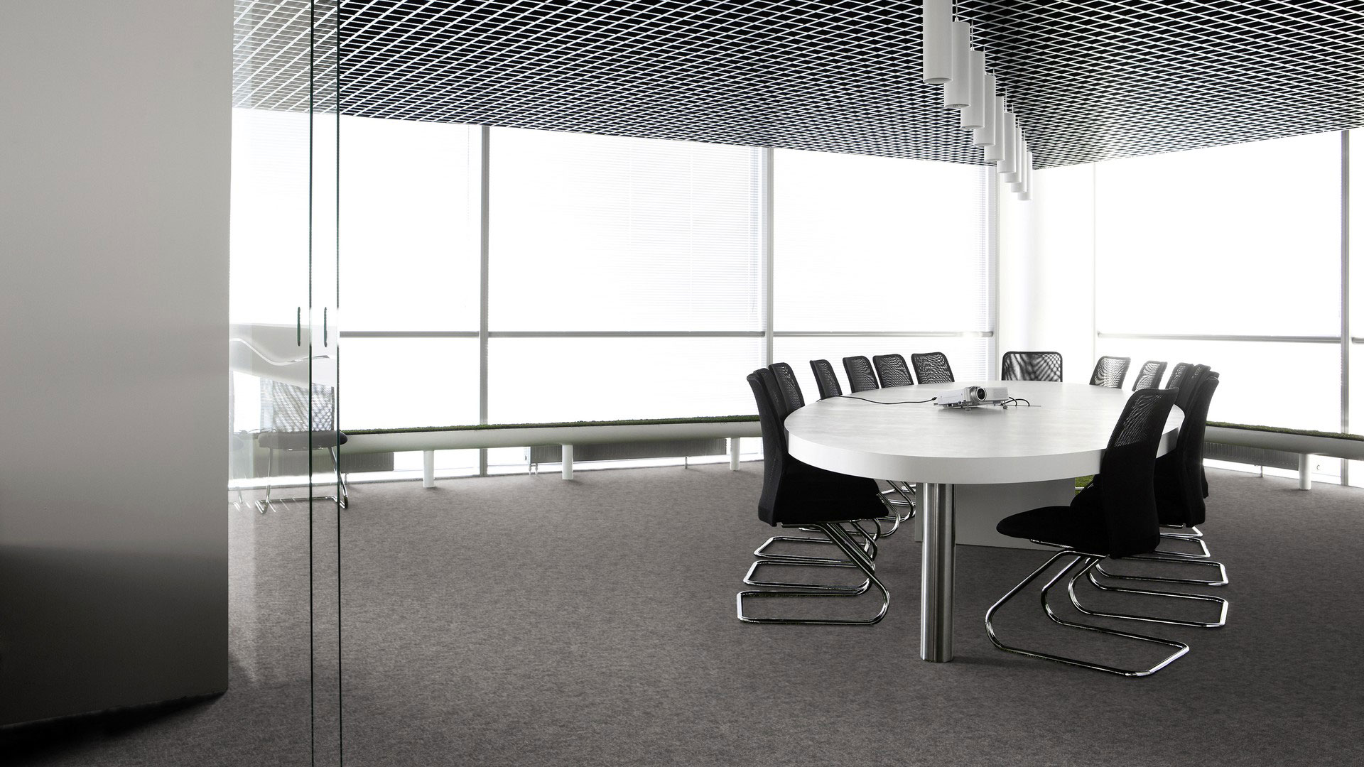 Ковровая плитка Desso Metallic Shades 9505 серого цвета в интерьере современной офисной переговорной комнаты с большим круглым столом.