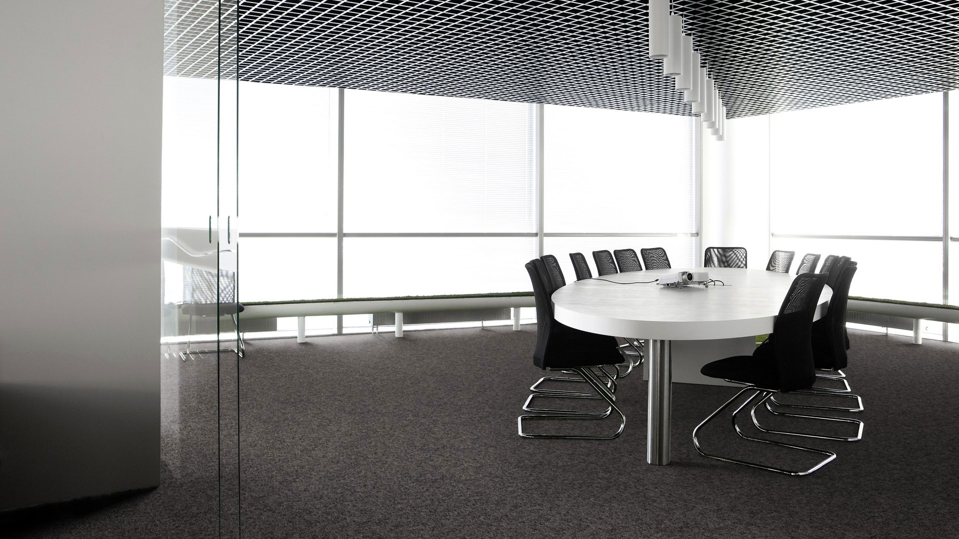 Ковровая плитка Desso Metallic Shades 9975 темно-серого цвета в дизайне современной офисной переговорной с панорамными окнами.
