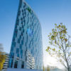 Напольные покрытия Tarkett на объекте Holiday Inn Hamburg - City Nord — вид на высотное застекленное здание отеля современной архитектуры.