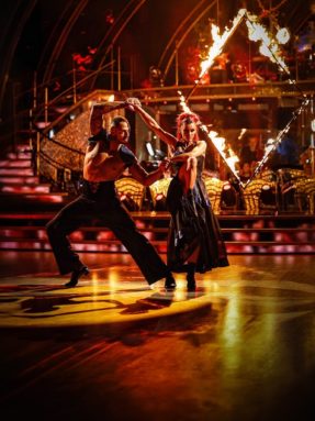 Танцевальный паркет Harlequin Liberty Ballroom на концертной сцене с огненным шоу. Профессиональное напольное покрытие Harlequin для бальных танцев во время экспрессивного парного выступления.