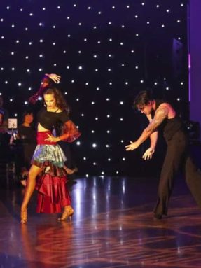 Пол Harlequin Liberty Ballroom на танцевальном шоу во время страстного латиноамериканского танца пары на паркете.