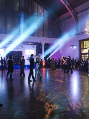 Пол Harlequin Liberty Ballroom на торжественном мероприятии во время танцев гостей в зале под лучами прожекторов.